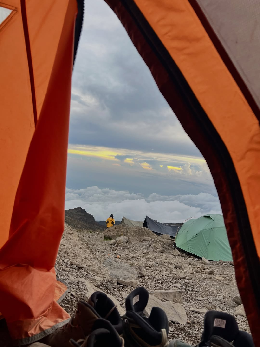 View from a Kilimanjaro tent across a high camp above the clouds