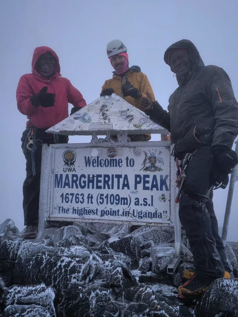 Geofrey and Kip with a Wilderness Alternative guest at Margherita Peak in the Rwenzori Mountains