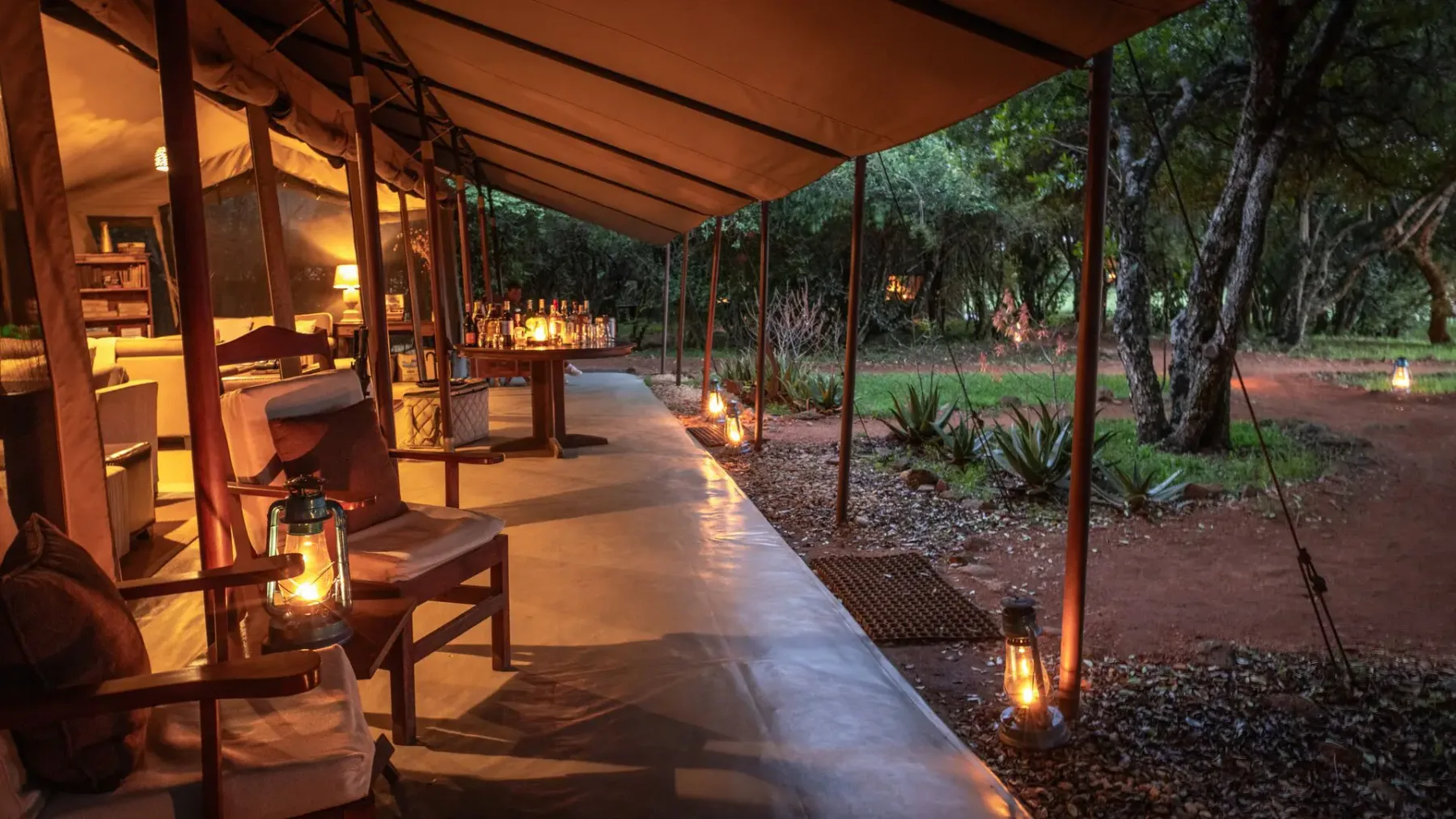 Lantern-lit lounge deck at Encounter Mara Camp in the Mara Naboisho Conservancy.