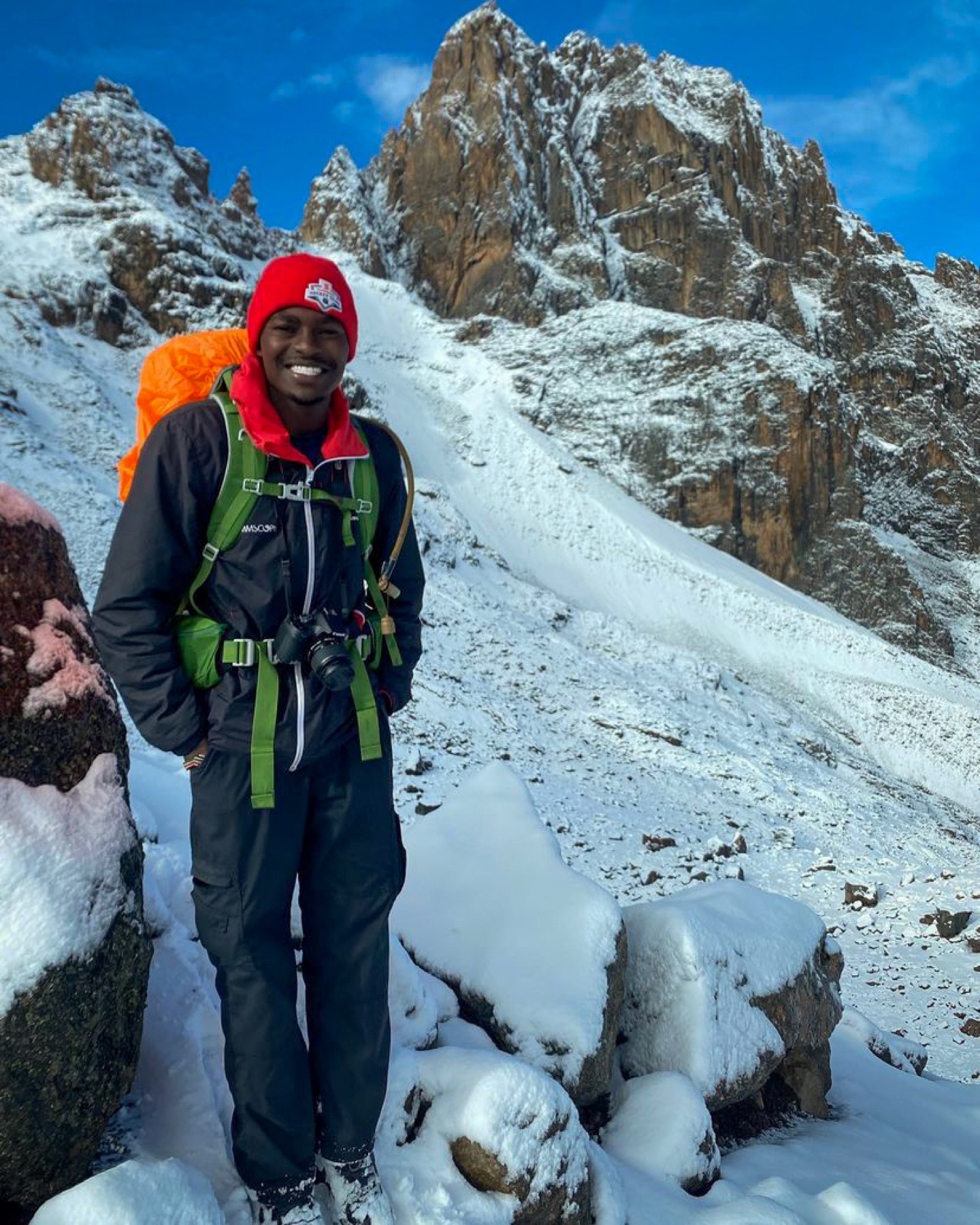 Kennedy Mutuma on Mount Kenya with Batian behind him