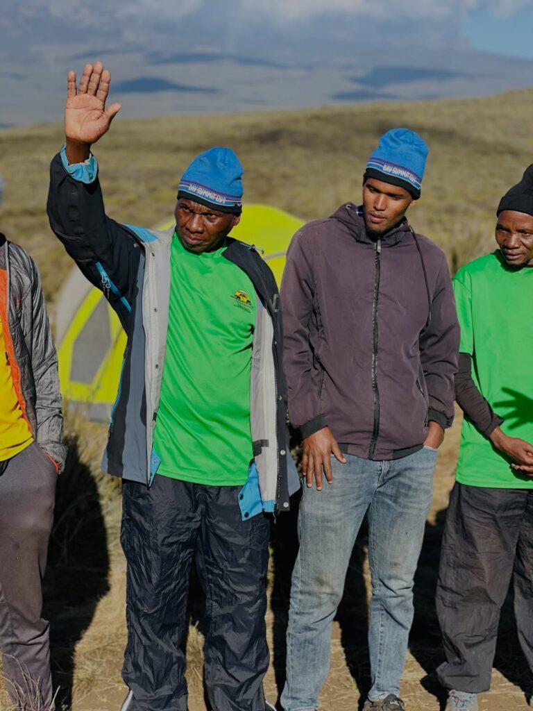 Kilimanjaro porters and guides gathered for a morning crew briefing at camp