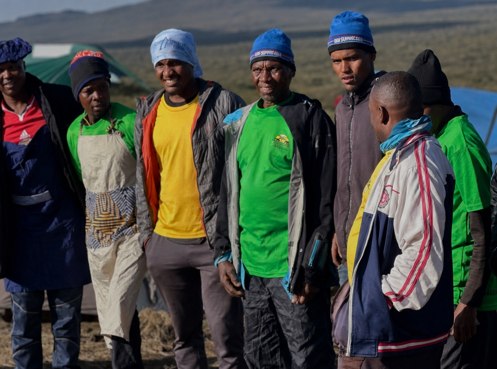 Wilderness Alternative Expedition Kilimanjaro guides, cooks and porters gathered at a mountain camp