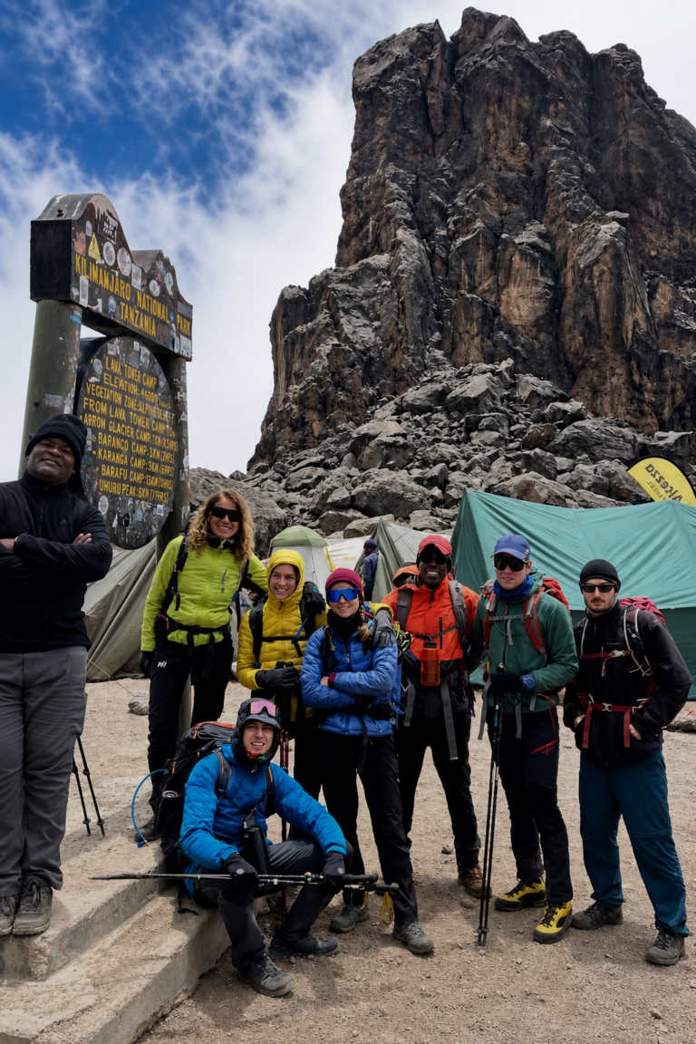 Trekkers and their Wilderness Alternative Expedition guide beside the Lava Tower cliffs on Mount Kilimanjaro