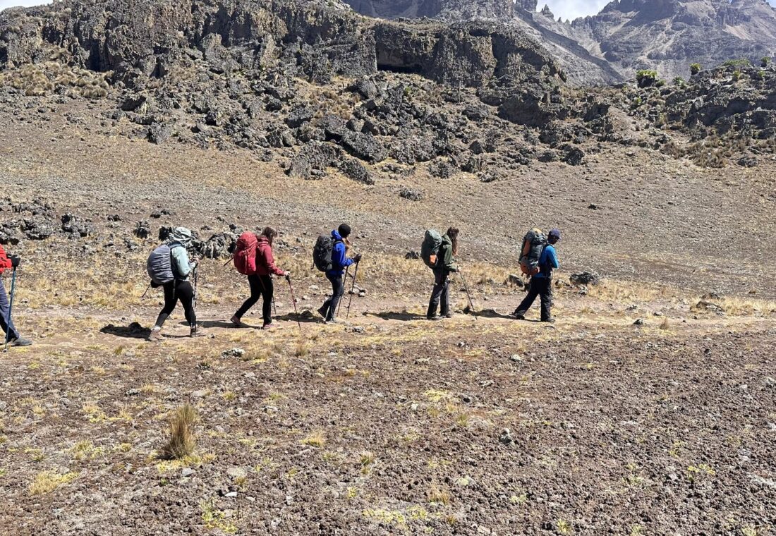 A guided trekking group crossing Mount Kenya’s high alpine terrain