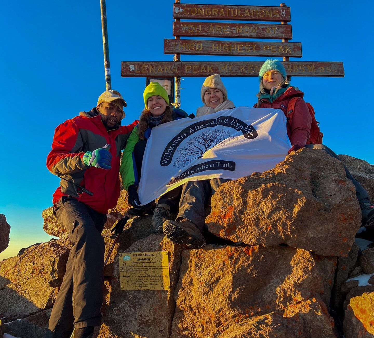 Wilderness Alternative Expedition guests and guide celebrating together at Point Lenana on Mount Kenya