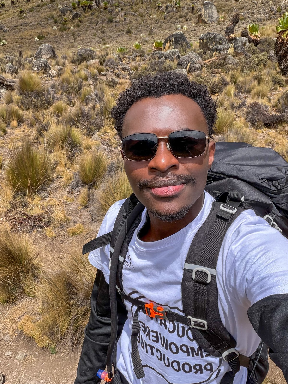Kenny, Mount Kenya guide and founder of Wilderness Alternative, hiking with an expedition backpack