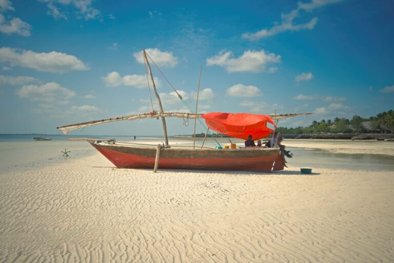 Traditional wooden dhow pulled onto a white-sand beach in Zanzibar