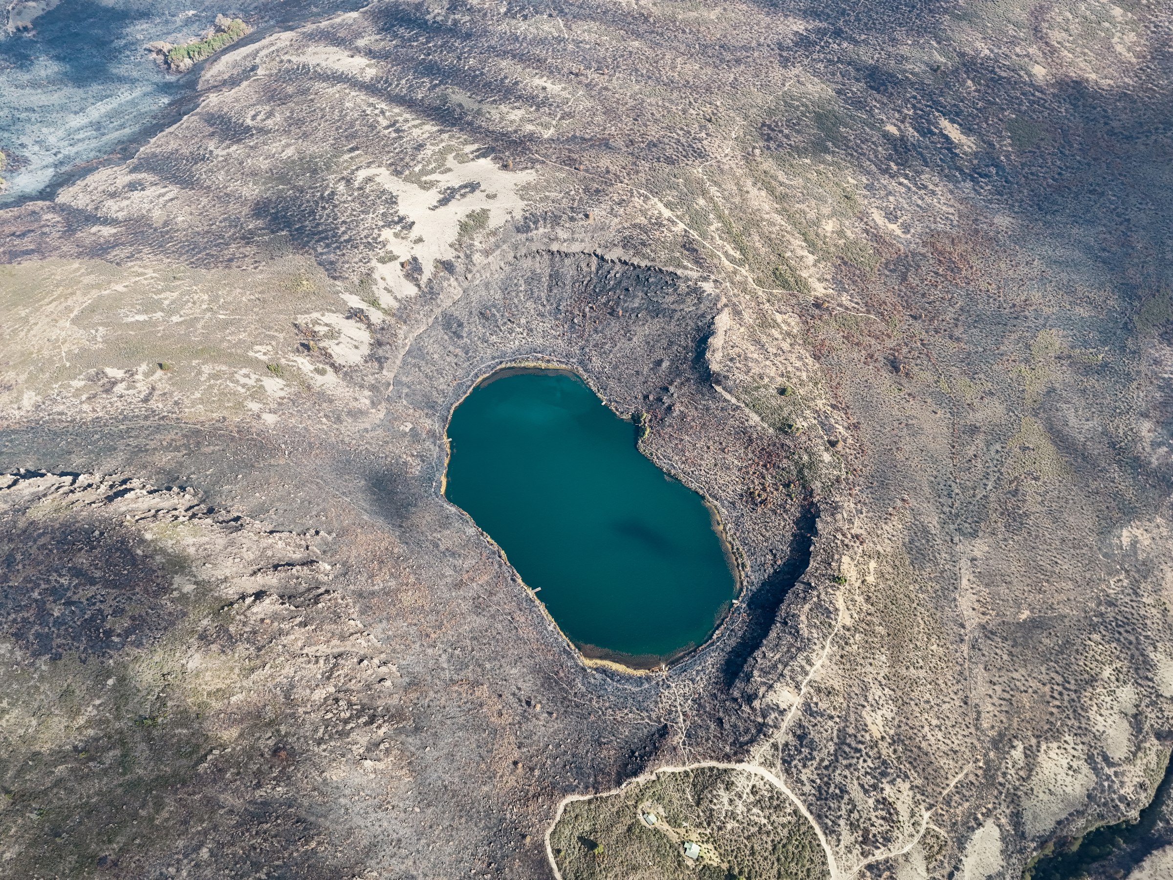 Aerial view of Lake Rutundu and the log cabins among the moorland slopes of Mount Kenya